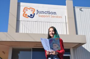 A young person reads Deep Dive outside of Junction Support Services